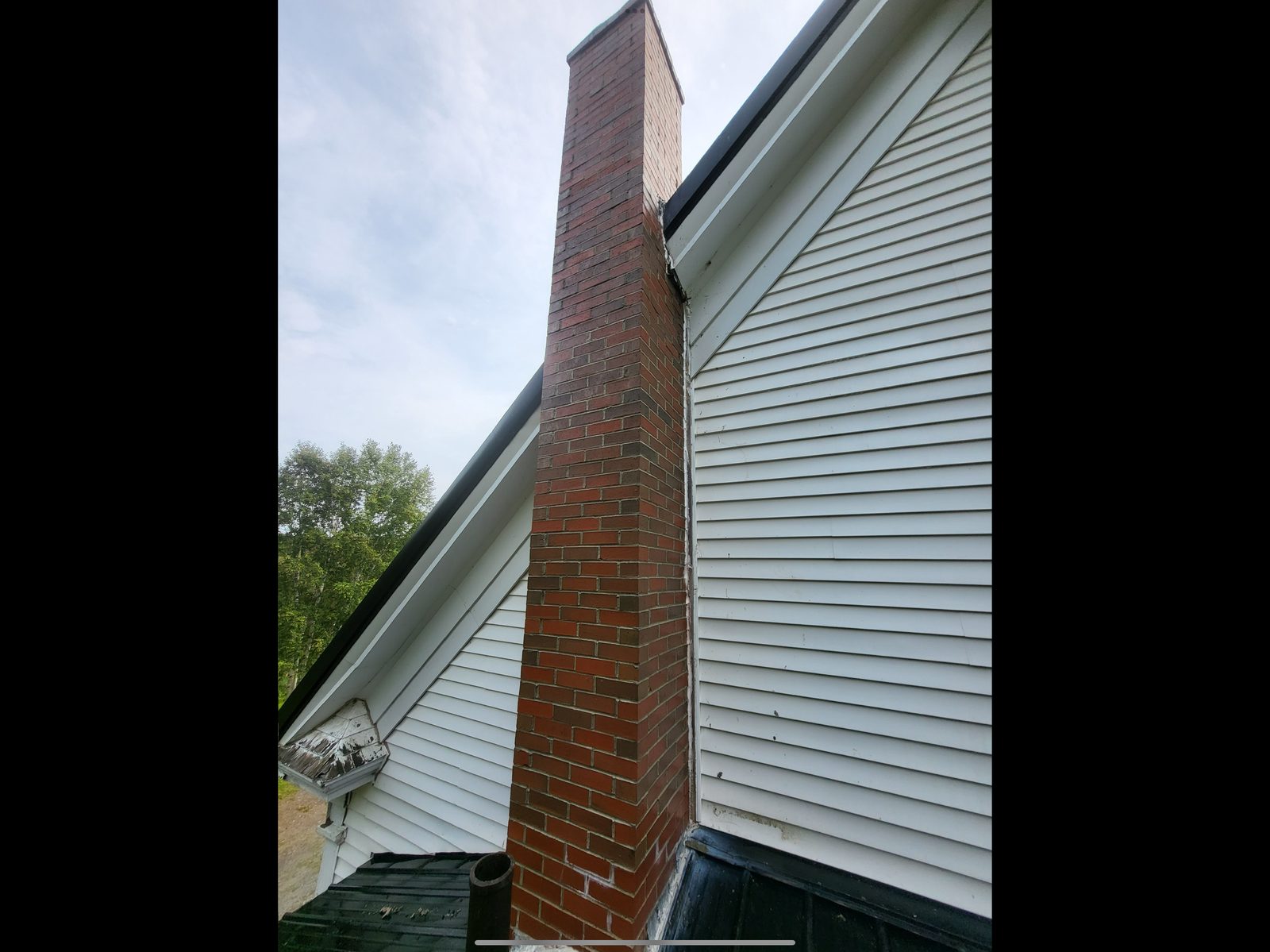 Finished brick chimney on white house