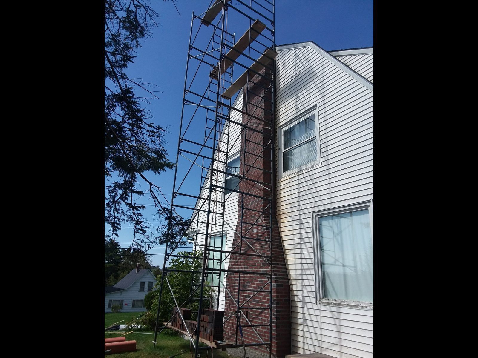 Tall brick chimney with full scaffolding setup