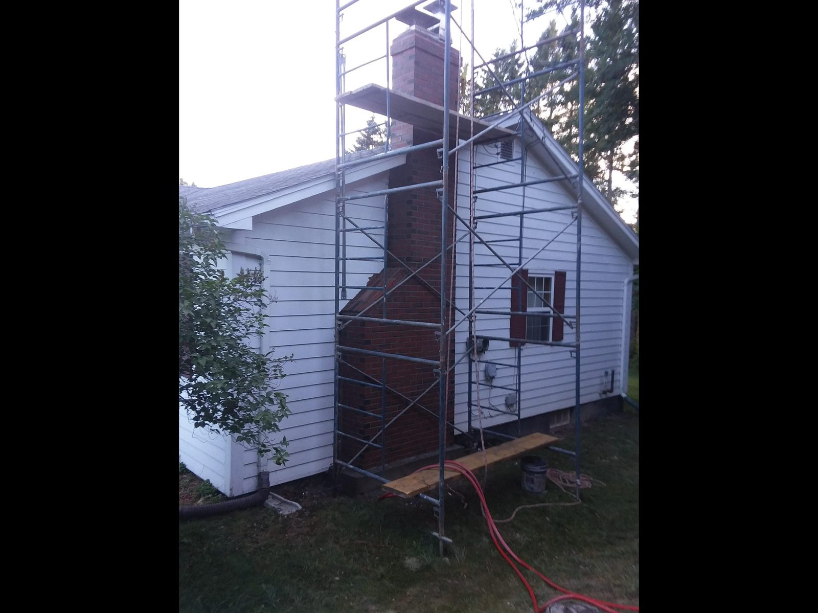 Chimney rebuild with scaffolding on white house