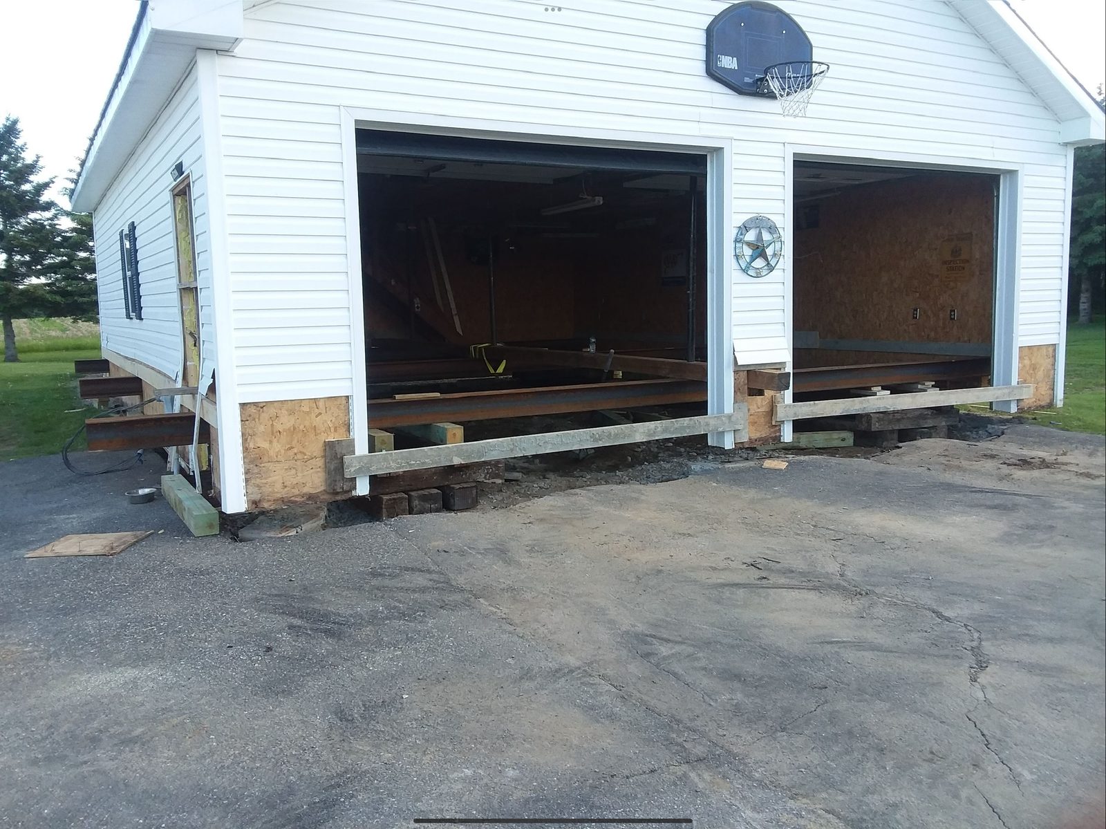 Garage lifted on steel I-beams for foundation work